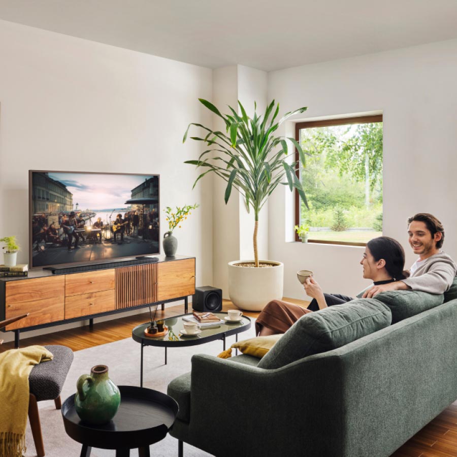 Paar schaut Fernsehen auf Smart TV im Wohnzimmer