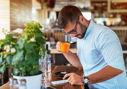 eve Mann mit Kaffee und Smartphone